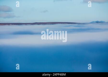 Ilkley, West Yorkshire, Großbritannien. 28.. November 2022. Wetter in Großbritannien. Nebel füllt das Tal unter den Rind- und Kalbfelsen auf dem berühmten Ilkley Moor bei Ilkley, West Yorkshire, Großbritannien. Die malerische Stadt Ilkley liegt im Wharfe Valley, am südlichen Ende der Yorkshire Dales. Die ehemalige Kurstadt wurde im 19. Jahrhundert berühmt, als Tausende wegen der frischen, belebenden Luft und erstklassigen Hotels zu Besuch kamen. Kredit: Windmill Images/Alamy Live News Stockfoto