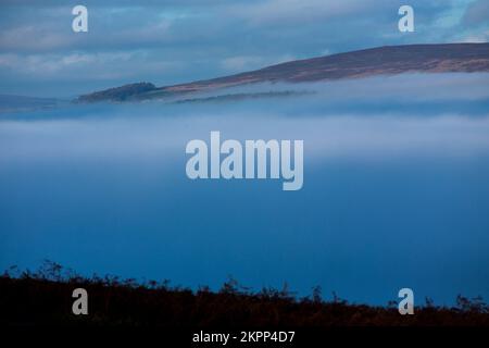 Ilkley, West Yorkshire, Großbritannien. 28.. November 2022. Wetter in Großbritannien. Nebel füllt das Tal unter den Rind- und Kalbfelsen auf dem berühmten Ilkley Moor bei Ilkley, West Yorkshire, Großbritannien. Die malerische Stadt Ilkley liegt im Wharfe Valley, am südlichen Ende der Yorkshire Dales. Die ehemalige Kurstadt wurde im 19. Jahrhundert berühmt, als Tausende wegen der frischen, belebenden Luft und erstklassigen Hotels zu Besuch kamen. Kredit: Windmill Images/Alamy Live News Stockfoto