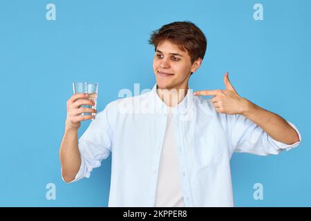 Junger, hübscher Mann mit einem Glas Wasser Stockfoto