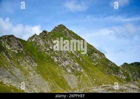 Berglandschaft, Gipfel der Bergkette. Nahaufnahme. Berggipfel vor blauem Himmel mit Wolken. Speicherplatz kopieren. Selektiver Fokus. Stockfoto