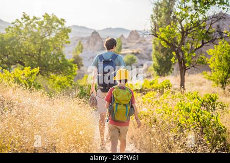 Vater und Sohn Touristen erkunden das Tal mit Felsformationen und Feenhöhlen in der Nähe von Goreme in Kappadokien, Türkei Stockfoto