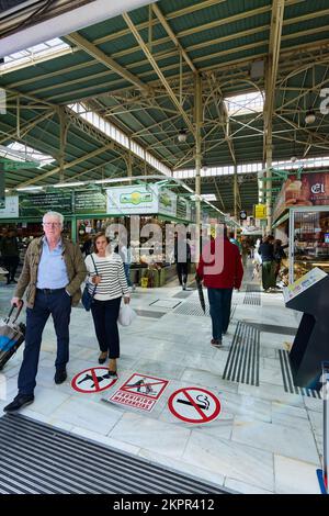 Oviedo, Spanien - 28. November 2022: Menschen, die den kommunalen Markt von Oviedo betreten und verlassen, im Konzept steigender Lebensmittelpreise aufgrund von Inflation und Stockfoto