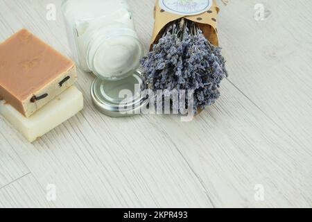 Handgefertigte kosmetische Cremebecher, Seife und getrocknete Lavendelblumen auf hellem Hintergrund. Bio-organische Kosmetik. Pflanzenbasis. Stockfoto