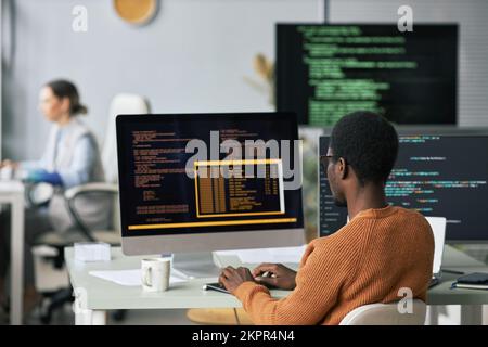 Junger Schwarzer testet Programmcode, den er für die neue Anwendung schrieb Stockfoto