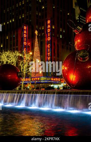 New York, NY – USA – 20. November 2022 Die berühmte beleuchtete Radio City Music Hall, die durch den Christmas Balls Fountain gesichtet wird, ist von oben Nach oben Zu sehen Stockfoto