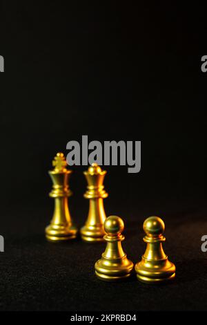 goldene Schachfiguren auf schwarzem Hintergrund. Stockfoto