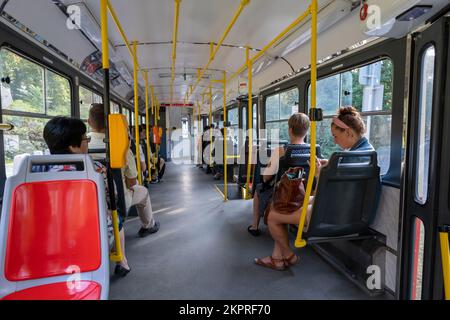 Prag, Tschechische Republik - 5. September 2022: Passagiere in einer roten Straßenbahn in der Altstadt von Prag Stockfoto