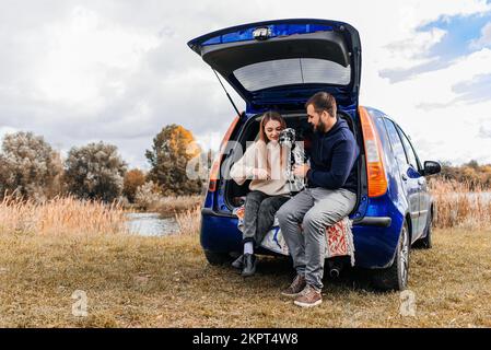 Ein junges Paar ruht sich aus, während es mit dem Auto reist. Stockfoto