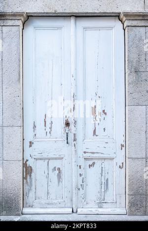 Charmantes Haus mit weißer, alter Holztür. Stockfoto