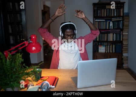 Überwältigt müde, junger afrikanischer Telearbeiter, der sich müde fühlt, den ganzen Tag vor dem Computer zu sitzen Stockfoto