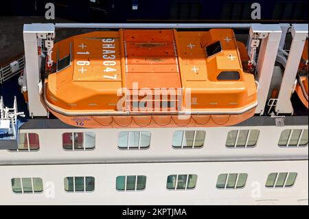 Kusadasi, Türkei - Mai 2022: Ariel-Blick auf ein leuchtend orangefarbenes Rettungsboot, das an der Seite eines Kreuzfahrtschiffs gelagert wird Stockfoto