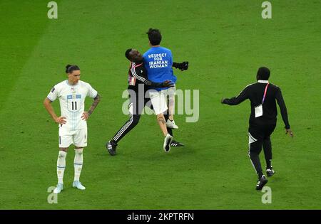 Ein Demonstrant in einer Spitzenlesung "Respect for Iranian Women", der von einem Steward während des Spiels der FIFA-Weltmeisterschaft Gruppe H im Lusail-Stadion in Lusail, Katar, angegriffen wurde. Foto: Montag, 28. November 2022. Stockfoto