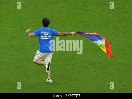 Während des Spiels der Gruppe H der FIFA-Weltmeisterschaft im Lusail-Stadion in Lusail, Katar, betritt ein Demonstrante in einer Top-Lesung „Respect for Iranian Women“ mit einer Regenbogenflagge das Spielfeld. Foto: Montag, 28. November 2022. Stockfoto