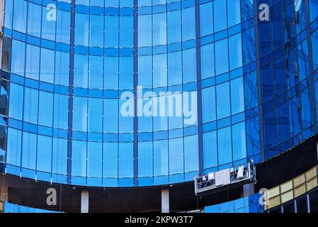 Ein Bruchteil der Konstruktion eines modernen Bürogebäudes und die Verglasung der Fassade mit blauen Glasfenstern. Stockfoto