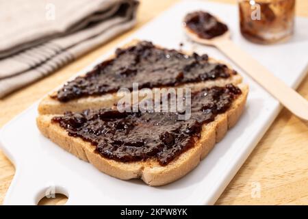 Nahaufnahme von weißem Brot, Toast, Sandwich und Himbeermarmelade aus biologischem Anbau auf einem Holztisch. Selektiver Fokus Stockfoto