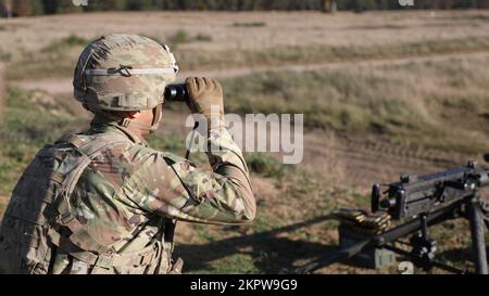 GREYWOLF-Soldat, Hauptquartier und Hauptquartier-Kompanie, 1.. Bataillon, 12.. Kavallerie-Regiment, 3.. Bewaffnete Brigaden-Kampfeinheit, 1.. Kavallerie-Division, blickt mit einem Fernglas auf das Ziel. 3. November 2022. Soldaten qualifizieren sich mit verschiedenen Waffensystemen, um die Bereitschaft zu gewährleisten und sicherzustellen, dass sie die Waffeneinsatzverfahren kennen. Stockfoto