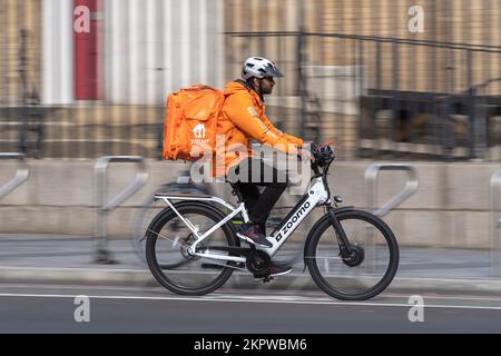 Ein Fahrrad-Kurier, der ein E-Bike fährt, Waterloo Road, London, Großbritannien. 16. Okt. 2022 Stockfoto