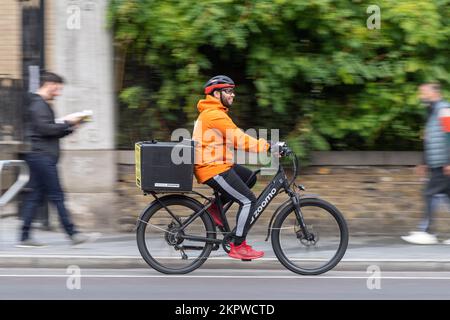 Ein Fahrrad-Kurier, der ein E-Bike fährt, Waterloo Road, London, Großbritannien. 16. Okt. 2022 Stockfoto