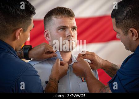 Mitglieder der Küstenwache ersetzen die Halsbänder von Petty Officer 2. Klasse Jacob Kulla, einem Bootsfreund des Coast Guard Maritime Safety & Security Team Houston, während er bei einem Treffen mit allen Händen am MSST Houston, Texas, am 3. November 2022 in Rang aufsteigt. Admiral Steven Poulin, Vizekommandant der Küstenwache, führte den Vorsitz über Kullas Aufstieg. Stockfoto