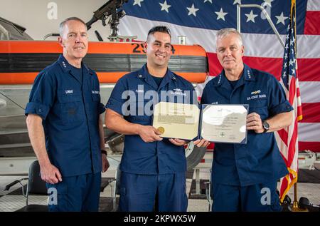 Coast Guard Petty Officer 2. Class Jake Flores, ein Spezialist für die Seeschifffahrt des Coast Guard Maritime Safety & Security Teams Houston, posiert für ein Foto mit Vice ADM Kevin Lunday, Commander der Coast Guard Atlantic Area, Und ADM. Steven Poulin, Vizekommandant der Küstenwache, nachdem er einen Preis während eines Treffens mit allen Händen am MSST Houston, Texas, am 3. November 2022 erhalten hatte. Flores erhielt am 2. Juni 2022 eine Medaille zur Erinnerung an die Küstenwache für die Rettung von drei Menschenleben auf dem Rio Grande an der Grenze zwischen den USA und Mexiko. Stockfoto