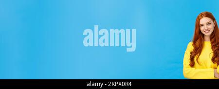 Taille-up-Shot attraktiv flirrrriger Rotkopf modernes Mädchen tausendjährige in gelbem Pullover, mit Haaren und lächelnd schön mit Unterhaltung, neugierig Stockfoto