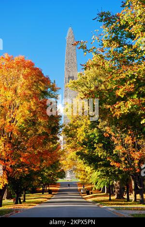 An einem sonnigen Herbsttag in Vermont, New England, umgeben der Obelisk des Bennington Battle Monument von Herbstfarben und Laubbbäumen Stockfoto