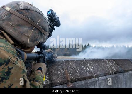 U.S. Marine Corps Lance CPL. Caleb Frazer, ein Einsatzleiter und stellvertretender Patrouillenführer mit 2. Platoon, Alpha Company, Fleet Anti-Terrorism Security Team, Marine Corps Security Force Regiment, reagiert auf einen simulierten Angriff für eine Marine Readiness Exercise (MRX) während der Tartan Eagle Phase II, nahe York, Europa, 3. November 2022. Ein MRX wird vor der Bereitstellung durchgeführt, um sicherzustellen, dass Marines in der Lage sind, wichtige Missionsziele zu erfüllen. Marines und Britische Royal Marines mit 43 Commando Fleet Protection Group Royal Marines, um sich gegenseitig zu den Trainingseinrichtungen zu reisen, um Taktiken und Techniken auszutauschen Stockfoto