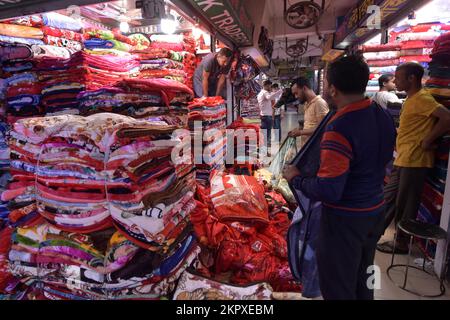 Dhaka. 28.. November 2022. Verkäufer arrangieren chinesische Decken auf einem Markt in Dhaka, Bangladesch, am 23. November 2022. Die Märkte in Dhaka sind jetzt vor der Hochsaison der Winterverkäufe voll ausgelastet. Dank ihrer Erschwinglichkeit und ihres attraktiven Designs ziehen mittlerweile viele Fachgeschäfte mit einer umfangreichen Sammlung chinesischer Decken viele Kunden an. Kredit: Xinhua/Alamy Live News Stockfoto