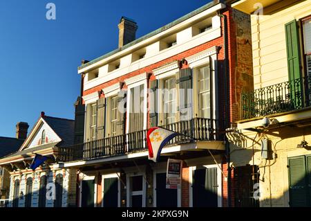 Eine Fleur de LIS Flagge fliegt von einem Balkon im New Orleans French Quarter Stockfoto