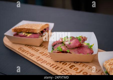 Frische Pastrami mit Frühlingszwiebeln in einer Papierbox beim Street Food Festival Stockfoto