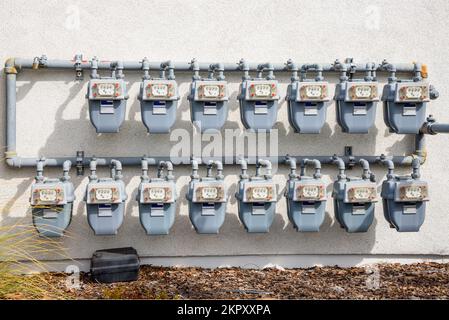 Reihen von Gaszählern an der Außenwand eines Apartmenthauses Stockfoto