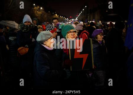 Eine Frau hält ein Schild mit einem Blitzschlagsymbol in der Hand, die Symbolik der Frauenrechtsbewegung während einer Kundgebung am 28. November 2022 in Warschau, Polen. Mehrere hundert Menschen nahmen an einer Kundgebung vor dem Haus des De-facto-Führers Jaroslaw Kaczynski Teil. Zuvor hat Kaczynski, dessen herrschende Partei für Recht und Gerechtigkeit (PiS) enge Verbindungen zur katholischen Kirche hat, öffentlich erklärt, dass die sinkende Geburtenrate durch Frauen verursacht wird, die wie Männer trinken. Polen hat einige der strengsten Abtreibungsgesetze der Welt und den schlechtesten Zugang der EU zu Empfängnisverhütung. (Foto: Jaap Arriens/Sipa USA) Stockfoto