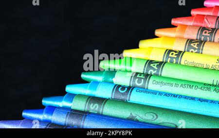 Buntstifte in der Regenbogenordnung auf dunklem Hintergrund. Stockfoto