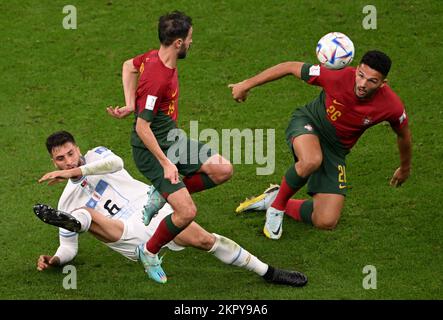 Lusail, Katar. 28.. November 2022. Rodrigo Bentancur (L) aus Uruguay tritt mit Bernardo Silva (C) und Goncalo Ramos aus Portugal während des Spiels der Gruppe H zwischen Portugal und Uruguay bei der FIFA-Weltmeisterschaft 2022 im Lusail-Stadion in Lusail, Katar, am 28. November 2022 auf. Kredit: Xia Yifang/Xinhua/Alamy Live News Stockfoto