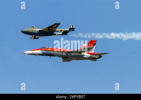 Eine Royal Canadian Air Force (RCAF) CF-18 und ein De Havilland Vampire auf einem traditionellen Flug während der Airshow London 2017. Stockfoto