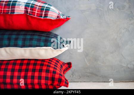 Nahaufnahme eines Stapels verschiedener Kissen mit verschiedenen Karomustern auf einem Regal Stockfoto