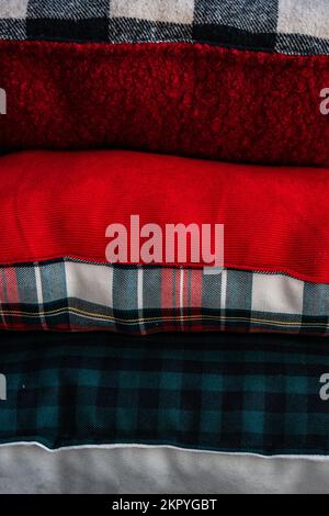 Nahaufnahme eines Stapels verschiedener Kissen mit verschiedenen Karomustern auf einem Regal Stockfoto