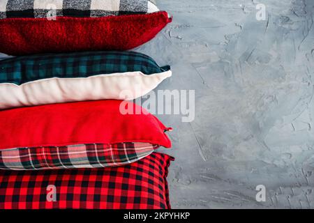 Nahaufnahme eines Stapels verschiedener Kissen mit verschiedenen Karomustern auf einem Regal Stockfoto