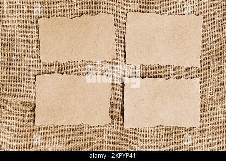 Altpapier auf Jutehintergrund. Braunes, zerrissenes Papier, zerrissene Papierreste auf Sacktuchhintergrund Stockfoto