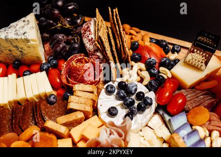 Käseplatte, Käseplatte, Fleisch und Brett. Gemüse und Obst mit Käse und Schokolade, Prosciutto und Salami mit Brot. Großes Snackboard für Stockfoto