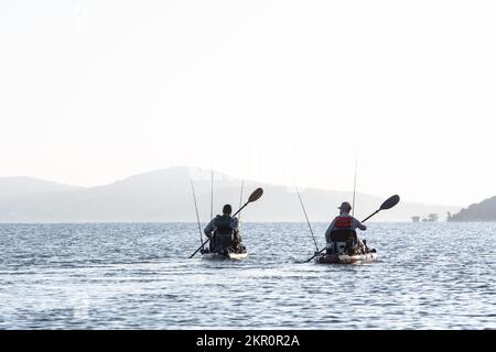 Zwei Kajakangler paddeln auf einem Texas-See und suchen nach Fischen Stockfoto