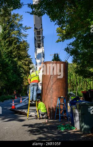 BELLEVUE, WA, USA – 30. SEPTEMBER 2022: Zwei Arbeiter stellen eine Antennenabdeckung für 5G Antennen zusammen, neue drahtlose Kommunikationstechnologie Stockfoto