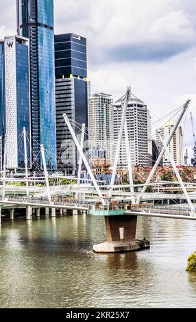 Vertikale Stadtlandschaft von urbanisierten Oberschwingungen mit Brücken, Hochhäusern und fließenden Gewässern. Kurilpa Bridge and Beyond - Brisbane, Queensland, Australi Stockfoto
