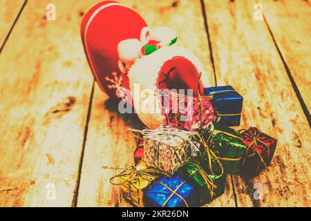 Foto der saisonalen Stillleben auf einem festlichen Weihnachtsstrumpf gefüllt Bis zum Rand mit dekorativen Weihnachtsgeschenken Stockfoto