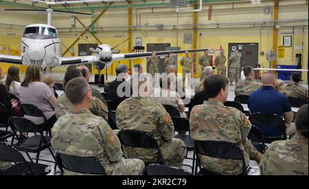 Die Zuschauer hören zu, dass sechs Soldaten der Nationalgarde der New Yorker Armee, die der Einheit 5 der Kompanie C, 2.. Bataillon, 245.. Luftfahrtregiment zugewiesen wurden, am 6. November 2022 in der Army Aviation Support Facility # 3 in Latham, New York, abgehalten wurden. Die Soldaten, die das C-12-Transportflugzeug der Huron fliegen, werden nach Dschibuti in Ostafrika entsandt, um die Streitkräfte der Vereinigten Staaten in der Region zu unterstützen. (USA Foto der Nationalgarde der Armee von Eric Durr) Stockfoto