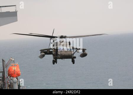 Einer von zwei USA Army UH-60m Black Hawk Helicopters vom 3.. Bataillon, 142.. Luftfahrtregiment, Assault Helicopter Bataillon, angeschlossen an 36. Combat Aviation Brigade, bereitet sich auf die Landung an Bord der USS Lewis B. Puller im Persischen Golf vor, 10. November 2022. Zwei US-Dollar Army UH-60m Black Hawks von 3-142. AHB und zwei AH-64E Apache Helikopter vom 1.. Bataillon, 101.. Luftfahrtregiment, Attack Helicopter Battalion, ebenfalls dem 36. CAB angeschlossen, führten Deckslandungen durch, um die Betriebsverfahren der USA zu erlernen Die Marine. 36. CAB, mobilisiert als Task Force Mustang, stellt Vollspektrum-Ar Stockfoto