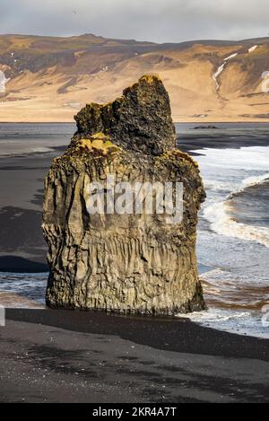 Nahaufnahme der beeindruckenden Basaltfelsformation Arnardrangur auf dem schwarzen Sand von Reynisfjara Beach, Island, von Dyrhólaey aus gesehen, in der Nähe der Route 1 Stockfoto
