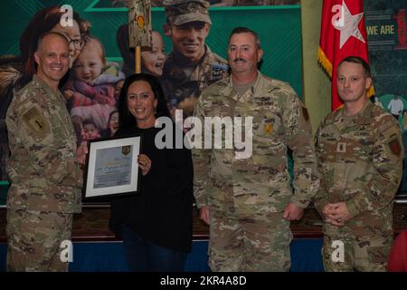 Jamie Oakley (Mitte links) erhält den Preis „Volunteer of the Quarter“ von Generalmajor John Meyer III (links), kommandierendem General der 1.. Infanteriedivision und Fort Riley, und Kommandosgt. Major Christopher Mullinax (rechts), Kommandosergeant Major der 1.. Inf. Div Und Fort Riley, 7. November 2022, in der Victory Hall in Fort Riley, Kansas. Oakley erhielt den Preis für ihre Freiwilligenarbeit bei Alpha, 1.. Geschwader, 4.. Kavallerie-Regiment-Soldatenfamilie-Bereitschaftsgruppe. Stockfoto