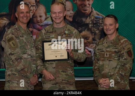 USA Army SPC. Owen Barnett (Mitte) erhält eine Military Outstanding Volunteer Service Medal von Major John Meyer III (links), kommandierendem General der 1.. Infanteriedivision und Fort Riley, und Kommandodirektor Major Christopher Mullinax (rechts), Kommandosergeant Major der 1.. Inf. Div Und Fort Riley, 7. November 2022, in der Victory Hall in Fort Riley, Kansas. Barnett erhielt die Medaille für seine ehrenamtliche Arbeit bei den Pfadfindern von Amerika. Stockfoto