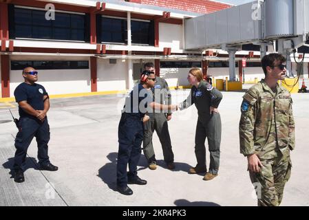 Edward Dela Cruz Jr., Flugzeugrettung und Feuerwehr, schüttelt sich die Hand mit Captain Peyton Wilkie, Pilot der 74.. Kampfstaffel, am Saipan International Airport in Saipan, Commonwealth der Nördlichen Marianen, 7. November 2022. 23. Air Expeditionary Wing Airmen und ARFF-Mitglieder lernten durch gemeinsame Einarbeitung in Flugzeuge und Notfallübungen für Ersthelfer. Stockfoto